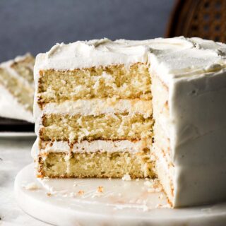 8 inch cake sliced open with three layers of vanilla cake and vanilla buttercream