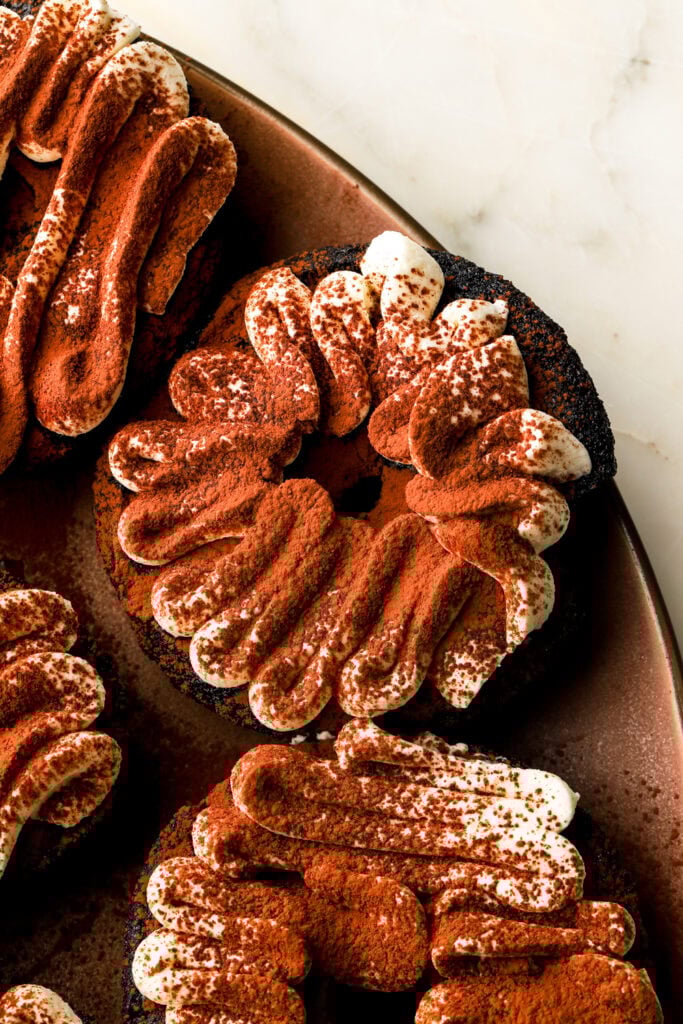 close up of chocolate tiramisu donuts with piping
