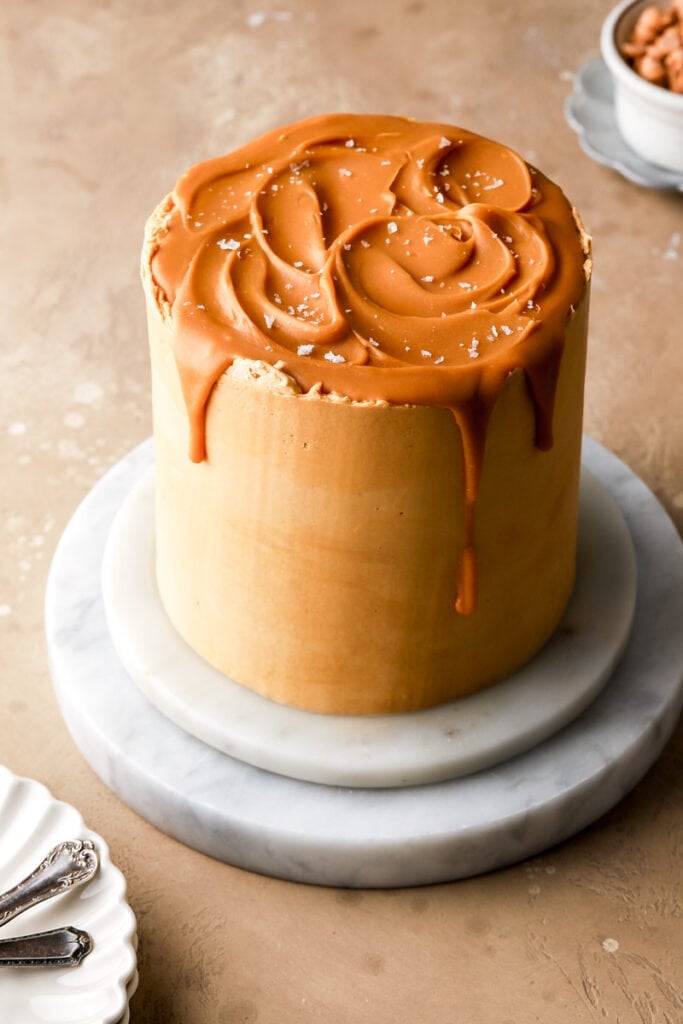 butterscotch cake with butterscotch drip and sea salt flakes on a marble board