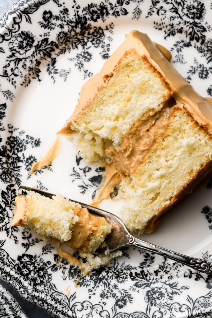 slice of dulce de leche cake on a plate with a bite taken out