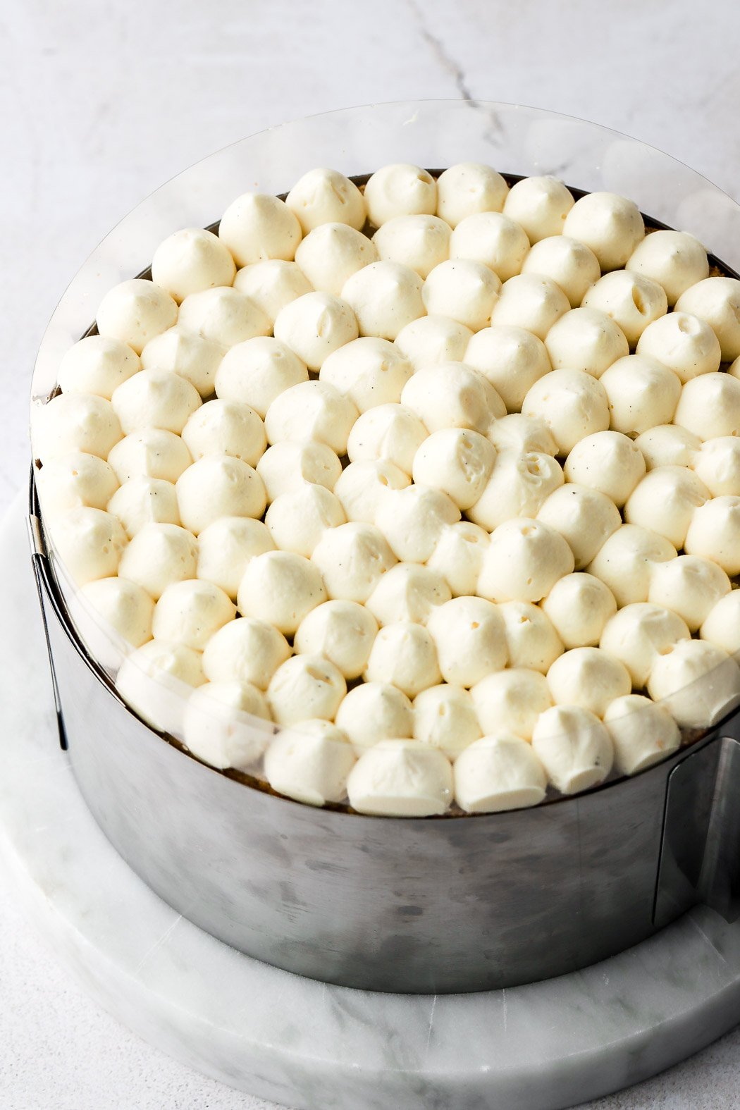 pipe poofs of crème mousseline on top of the cake