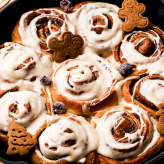Gingerbread cinnamon rolls in a pan with icing on top