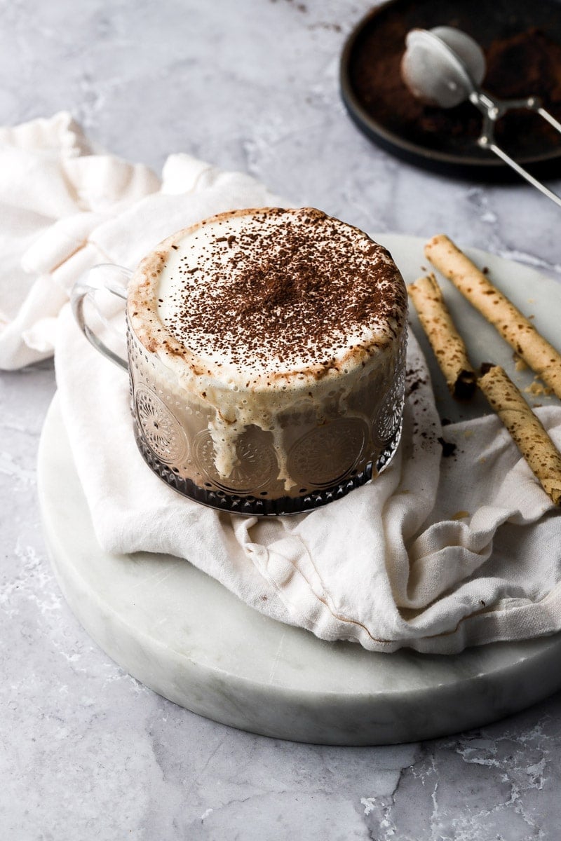 tiramisu latte spilling over the cup with mascarpone cream