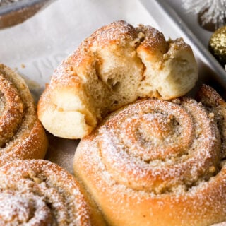 vanilla walnut roll dusted with powdered sugar and a bite taken out